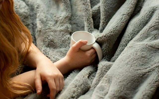 Warm drink and blanket for feeling cozy in winter